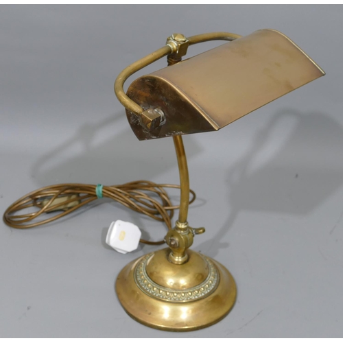 776 - An early brass desk lamp with revolving shade, on round sweeping base, 40cm high.