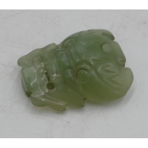 777 - A jade style buckle in form of a mask, 6.5cm high.