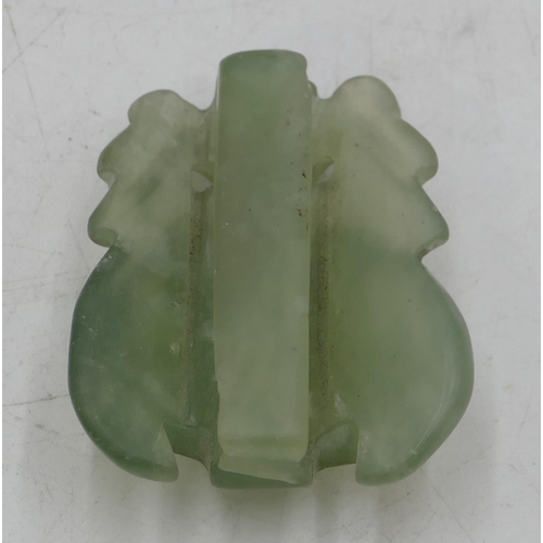 777 - A jade style buckle in form of a mask, 6.5cm high.