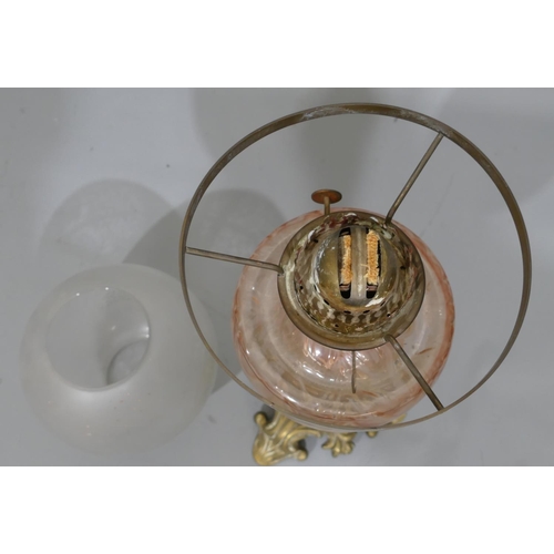 778 - A brass oil lamp with pink glass bowl and clear glass later shade, on Corinthian column support and ... 