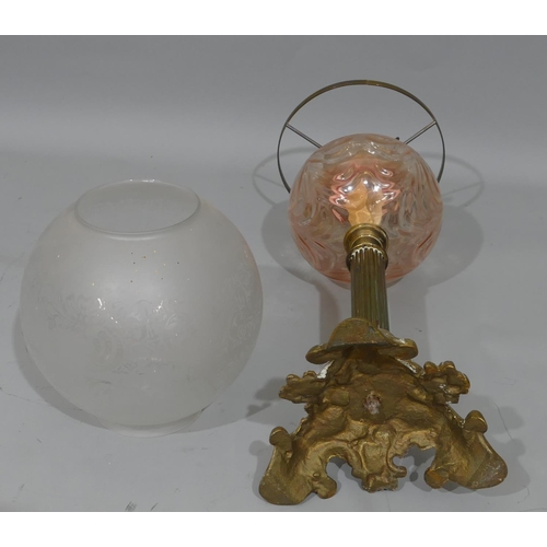 778 - A brass oil lamp with pink glass bowl and clear glass later shade, on Corinthian column support and ... 