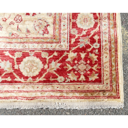 779 - A Persian rug on cream and red ground with allover medallions, 1 meter 77 x 1 meter 23cm.