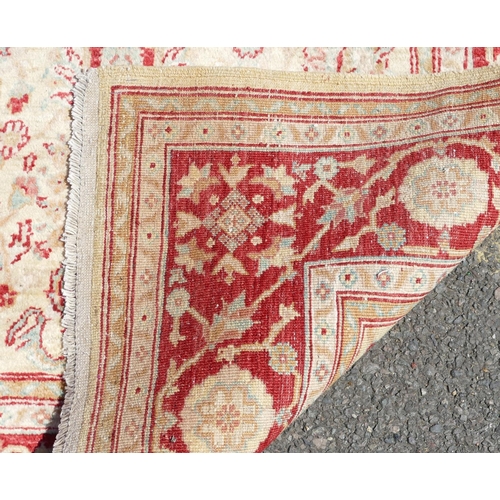 779 - A Persian rug on cream and red ground with allover medallions, 1 meter 77 x 1 meter 23cm.