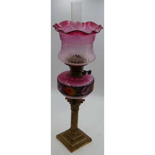 796 - A brass Corinthian paraffin lamp with pink glass bowl and painted floral and leaf decoration with fu... 