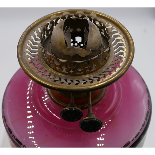 796 - A brass Corinthian paraffin lamp with pink glass bowl and painted floral and leaf decoration with fu... 