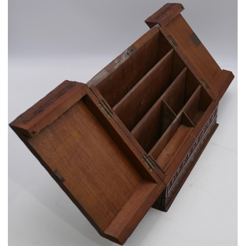 797 - A carved wooden stationery box with sloping double hinged front with raised leaf and scroll decorati... 