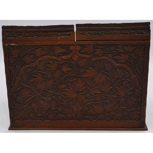 797 - A carved wooden stationery box with sloping double hinged front with raised leaf and scroll decorati... 