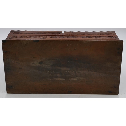 797 - A carved wooden stationery box with sloping double hinged front with raised leaf and scroll decorati... 