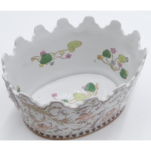 8 - A reproduction oval jardiniere with crinkled rim on white ground and multi-coloured cupid. floral an... 