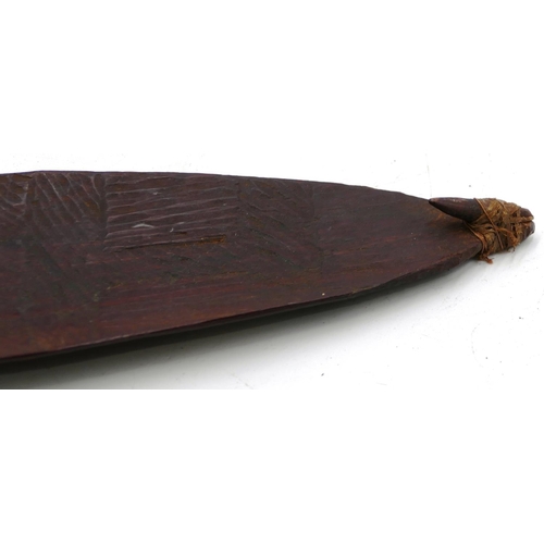 802 - An Australian Aboriginal Woomera spear thrower, attached with hook with allover carved decoration to... 