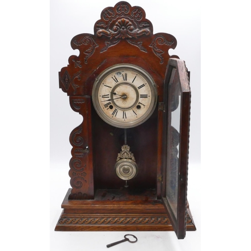 834 - An American Ansonia mantle clock with allover carved decoration, glass door enclosing cream dial wit... 