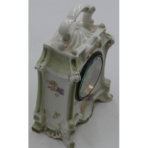 846 - A China timepiece with overhead carrying handle on white and green ground with multicolour floral le... 