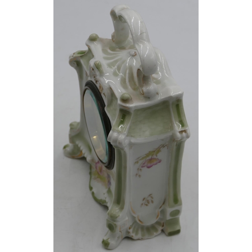 846 - A China timepiece with overhead carrying handle on white and green ground with multicolour floral le... 