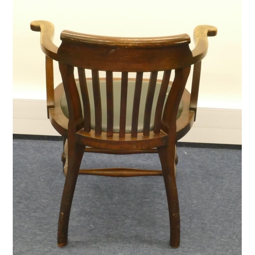 857 - A 1930's oak tub desk chair with stick back, green leather overstuffed seat and on round turned legs... 