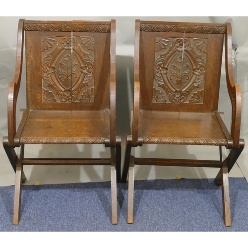 864 - A pair of oak Bishop's chairs with solid seats, carved panelled backs with floral, leaf and scroll d... 