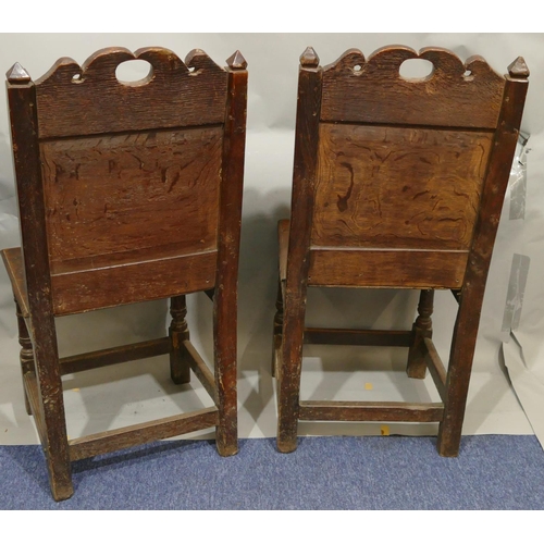 868 - A pair of 18th Century oak hall chairs with carved panel backs and floral leaf and scroll decoration... 