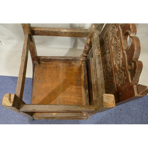 868 - A pair of 18th Century oak hall chairs with carved panel backs and floral leaf and scroll decoration... 