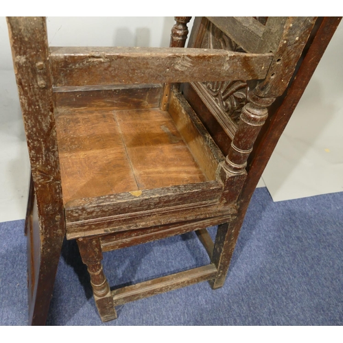 868 - A pair of 18th Century oak hall chairs with carved panel backs and floral leaf and scroll decoration... 