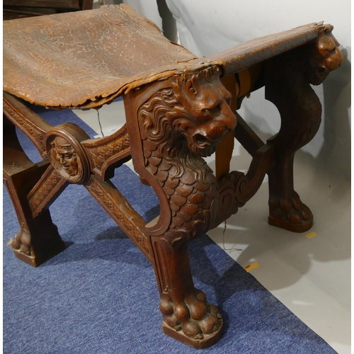 869 - A 19th Century large heavily carved oak stool with concave leather seat (leather in need of restorat... 