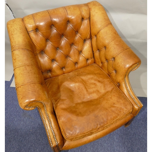 873 - A mahogany framed and brown leather armchair with buttoned back, sides and studded decoration, leath... 