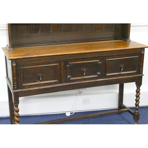 878 - A 1920's oak dresser with small leaded glass panelled door surrounded by shelves, 1 long drawer and ... 