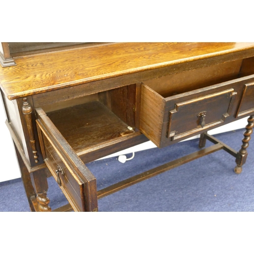 878 - A 1920's oak dresser with small leaded glass panelled door surrounded by shelves, 1 long drawer and ... 