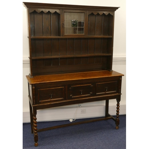 878 - A 1920's oak dresser with small leaded glass panelled door surrounded by shelves, 1 long drawer and ... 