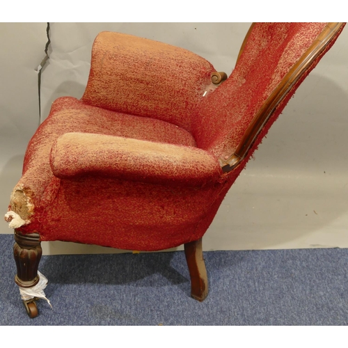 881 - A Victorian mahogany framed spoon back armchair with overstuffed seat, button back and padded arms (... 