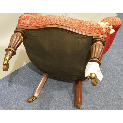 881 - A Victorian mahogany framed spoon back armchair with overstuffed seat, button back and padded arms (... 