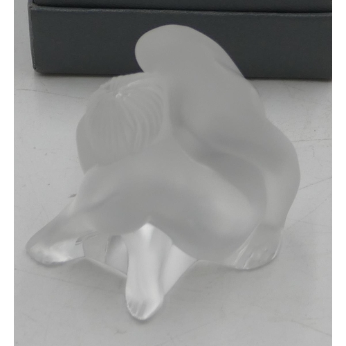 104 - A Lalique frosted glass figurine of a seated female nude, 6cm high, signed and boxed.