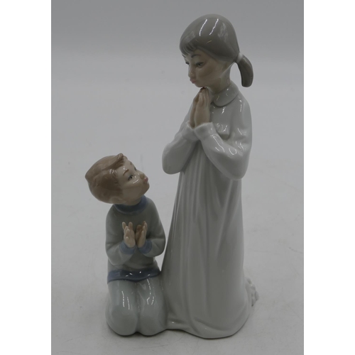 112 - A Lladro group of a kneeling young girl and boy praying, 22cm high.