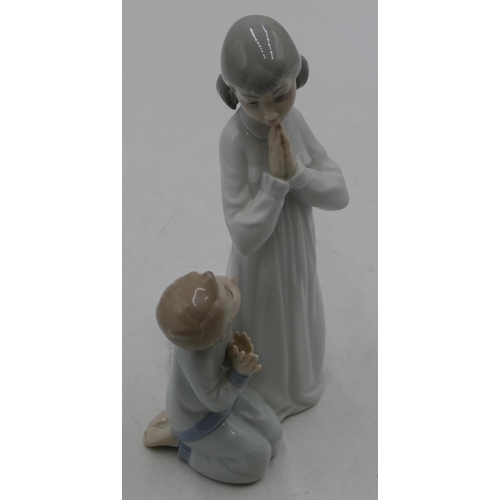 112 - A Lladro group of a kneeling young girl and boy praying, 22cm high.