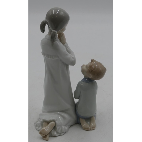 112 - A Lladro group of a kneeling young girl and boy praying, 22cm high.