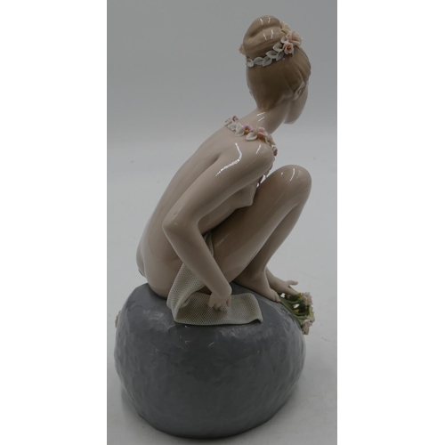 115 - A Lladro figure of a seated female nude on rock with allover encrusted floral decoration, 29.5cm hig... 