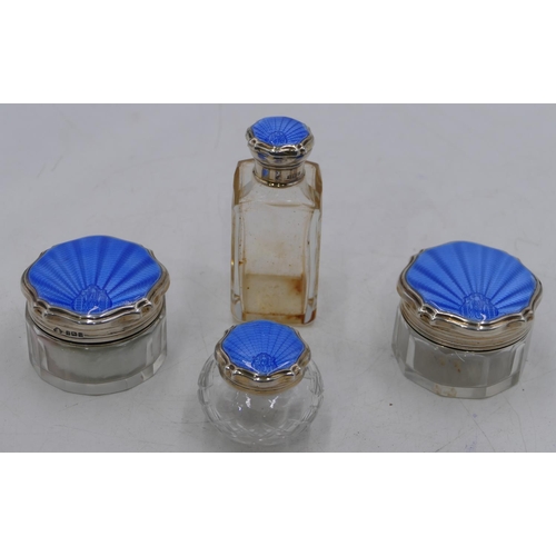 159 - A set of 4 cut glass dressing table bottles with Birmingham silver and blue enamelled lids (4)