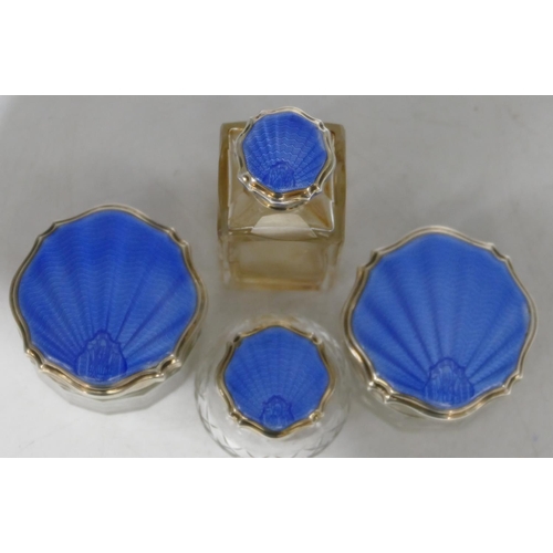 159 - A set of 4 cut glass dressing table bottles with Birmingham silver and blue enamelled lids (4)