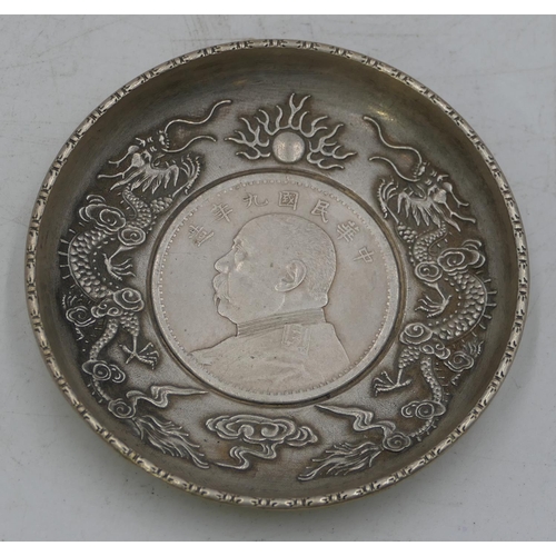 161 - An Oriental small circular dish inset with centre coin surrounded by 2 raised dragons, 8cm diameter.