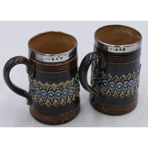 17 - A pair of 19th Century Royal Doulton glazed earthenware tankards with silver rims on green and brown... 