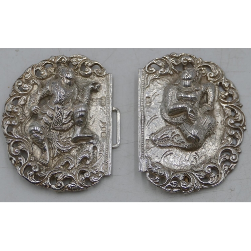 181 - An Eastern silver-coloured metal buckle with embossed and pierced figure and scroll decoration, 9.4c... 