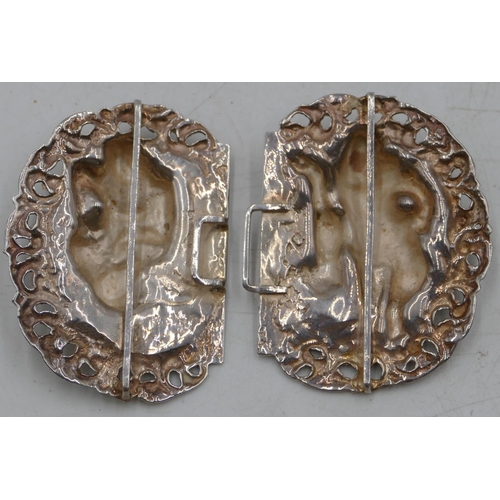 181 - An Eastern silver-coloured metal buckle with embossed and pierced figure and scroll decoration, 9.4c... 