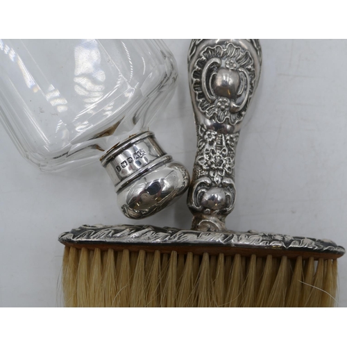 183 - A Birmingham silver handled crumb brush with embossed decoration and a cut glass dressing table bott... 