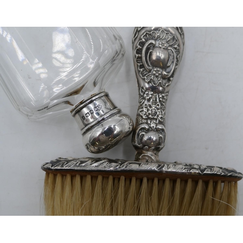 183 - A Birmingham silver handled crumb brush with embossed decoration and a cut glass dressing table bott... 