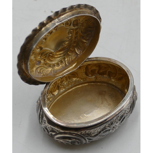 186 - A Birmingham silver oval bulbous shaped pill box with hinged lid, allover embossed floral, leaf and ... 