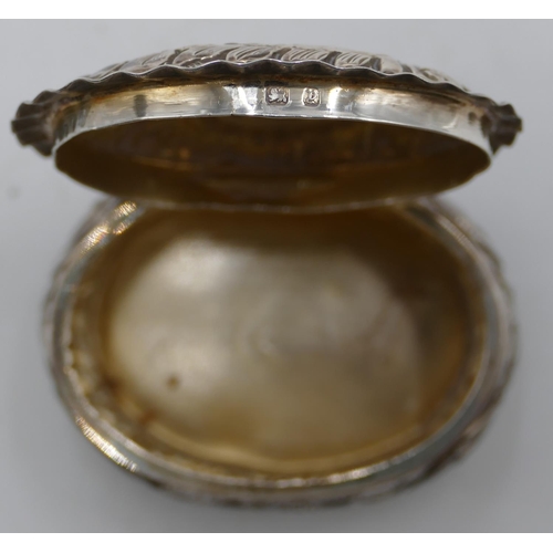 186 - A Birmingham silver oval bulbous shaped pill box with hinged lid, allover embossed floral, leaf and ... 