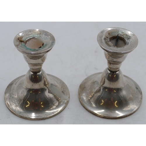 220 - A pair of Continental silver-coloured metal dwarf candlesticks on round sweeping bases, 9cm high.