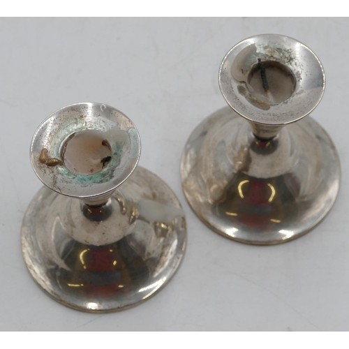 220 - A pair of Continental silver-coloured metal dwarf candlesticks on round sweeping bases, 9cm high.