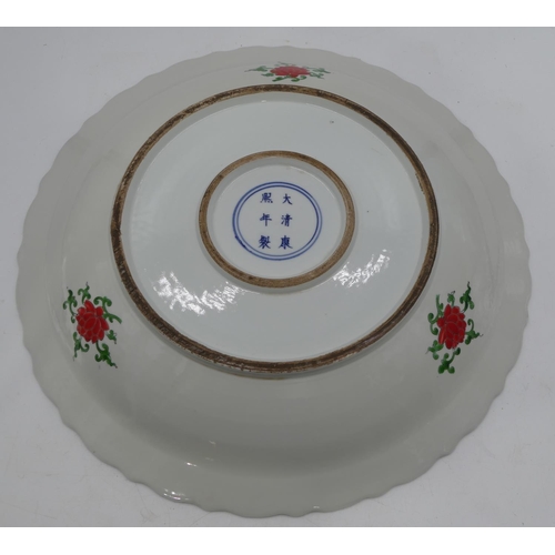 23 - A 20th Century Chinese round charger with crinkled rim on white ground with multi-coloured floral, l... 