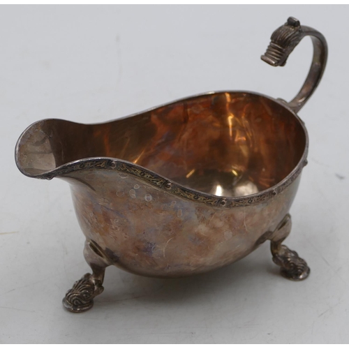 234 - A Birmingham silver sauce boat with scroll handle with animal motif on splayed feet, maker ADI Bros ... 