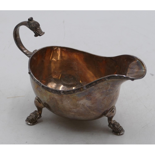 234 - A Birmingham silver sauce boat with scroll handle with animal motif on splayed feet, maker ADI Bros ... 