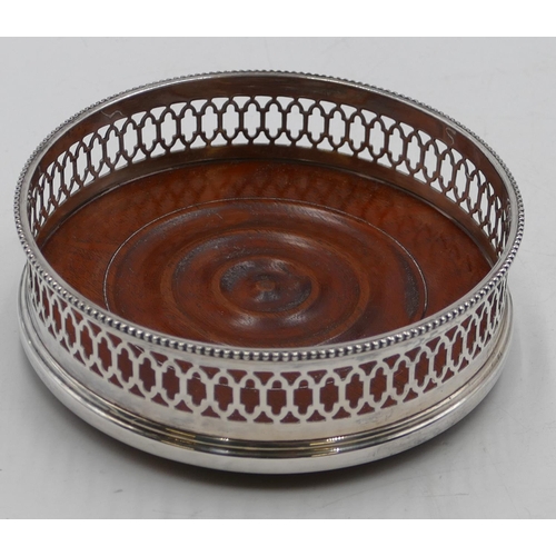 259 - A modern London silver wine coaster with pierced rim and wooden centre, 13cm diameter.